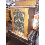 An oak smoker's cabinet with Art Nouveau beaten metal panel.