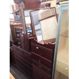 A suite of dark wood veneer bedroom furniture comprising a dressing table with mirror and stool,