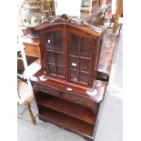 A glazed table top cabinet and an open bookcase with drawers.