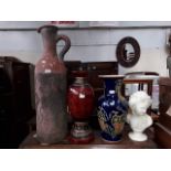 A large red clay ewer with incised figures, two vases and a female bust.