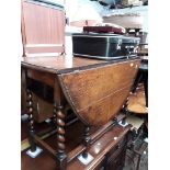 An oak drop leaf table with barley twist legs, together with a vintage suitcase and two small