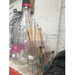 An artists paintbrush display stand and a large plastic Coca Cola bottle