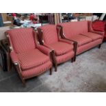 An Edwardian inlaid mahogany three piece suite comprising a pair of wing back armchairs and scroll