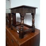 A joined oak stool with carved frieze, early 20th century, height 38cm.