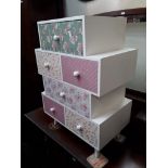 A white painted and decorated set of drawers on tapered legs, H74cm, W53cm, D32cm.