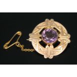 A late Victorian Celtic target brooch set with a central round cut amethyst, James fenton,