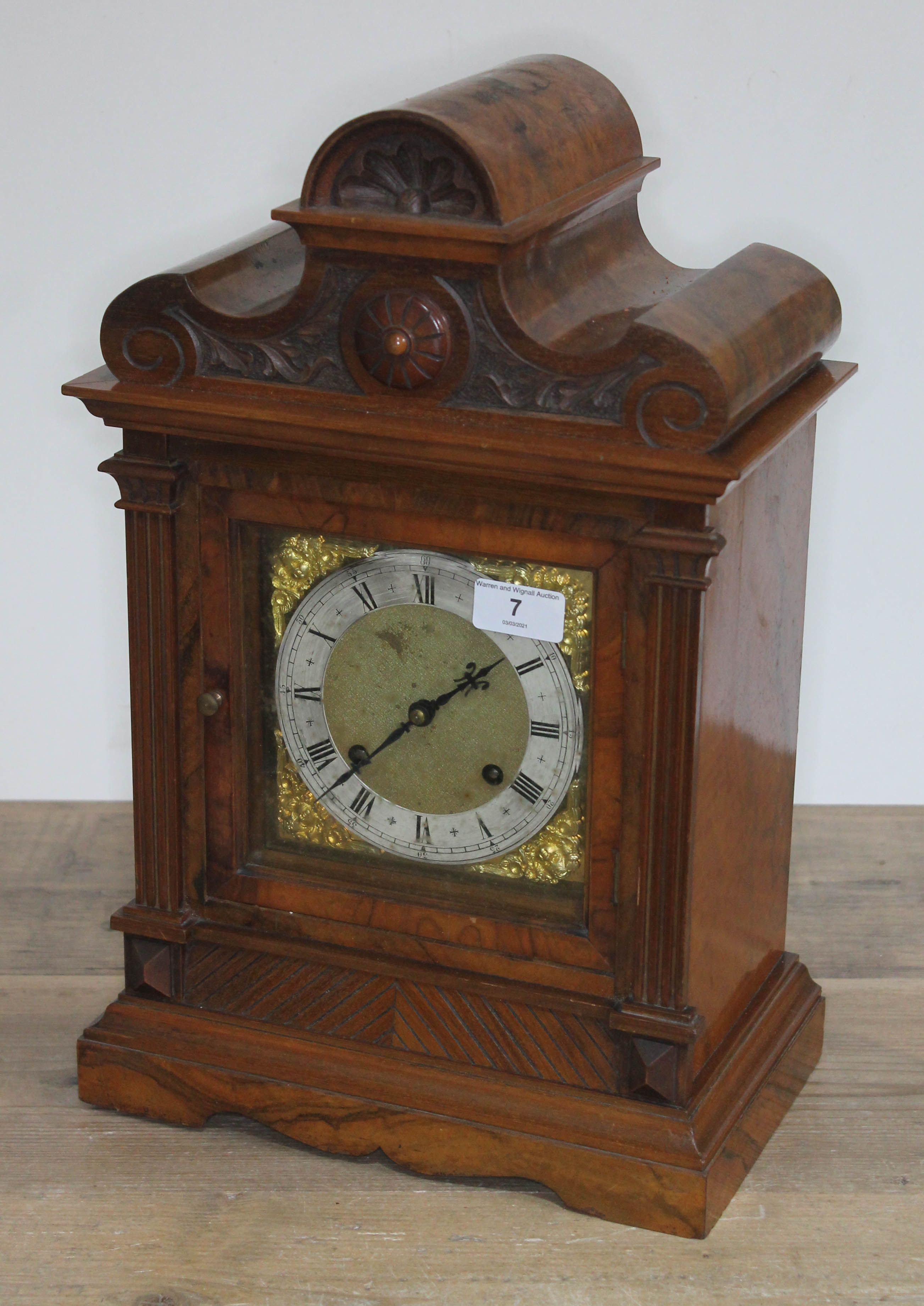 A late 19th century architectural walnut mantel clock with brass and silvered dial, twin spring