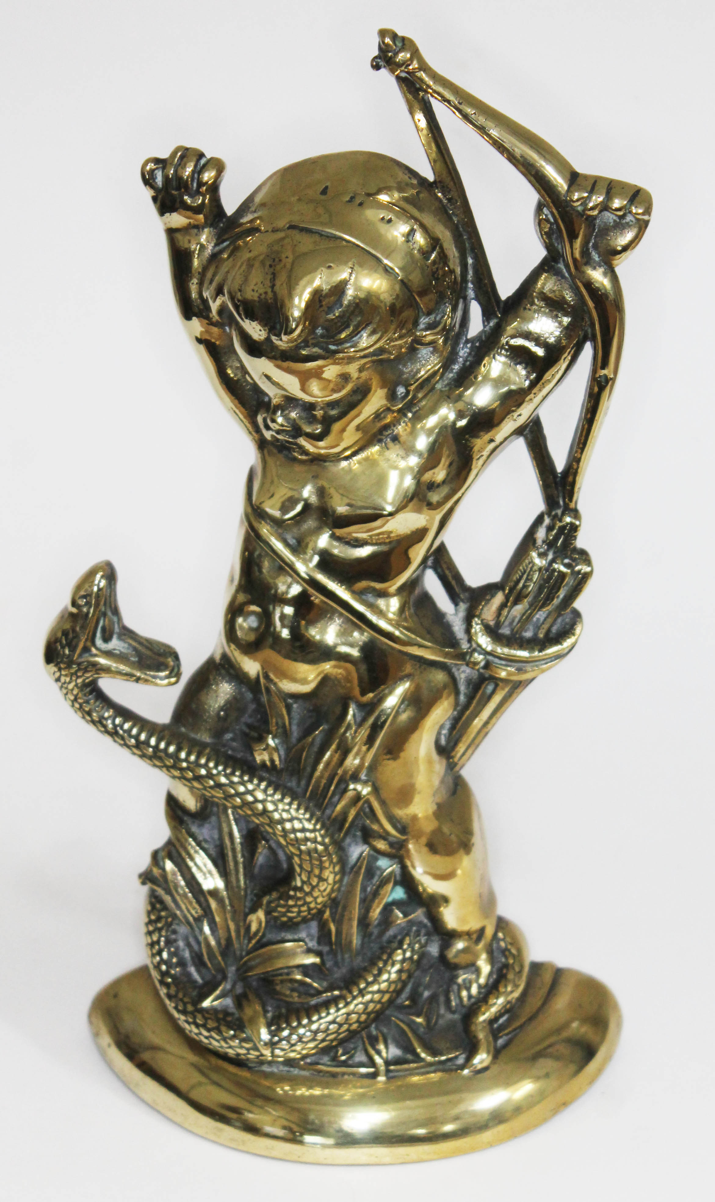 An early 19th century lead weight brass door stop formed as cupid fighting a serpent, number 8310,