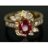 A ruby and diamond cluster ring, the central ruby weighing approx. 1 carats, surrounded by baguette,
