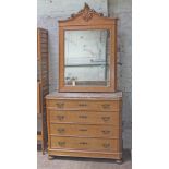 A continental birds eye maple chest of drawers with mirror back having carved scroll pediment, the
