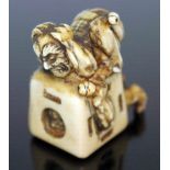 A Japanese carved ivory netsuke formed as an oni catcher on top of a box with protruding limbs,