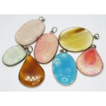 A group of seven white metal mounted pendants set with quartz variety cabochons, lengths 33mm to