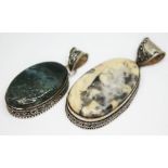 Two eastern white metal pendants, one set with a moss agate cabochon and the other a cream and