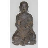 A Bronze buddha seated and holding a rat, height 16cm.