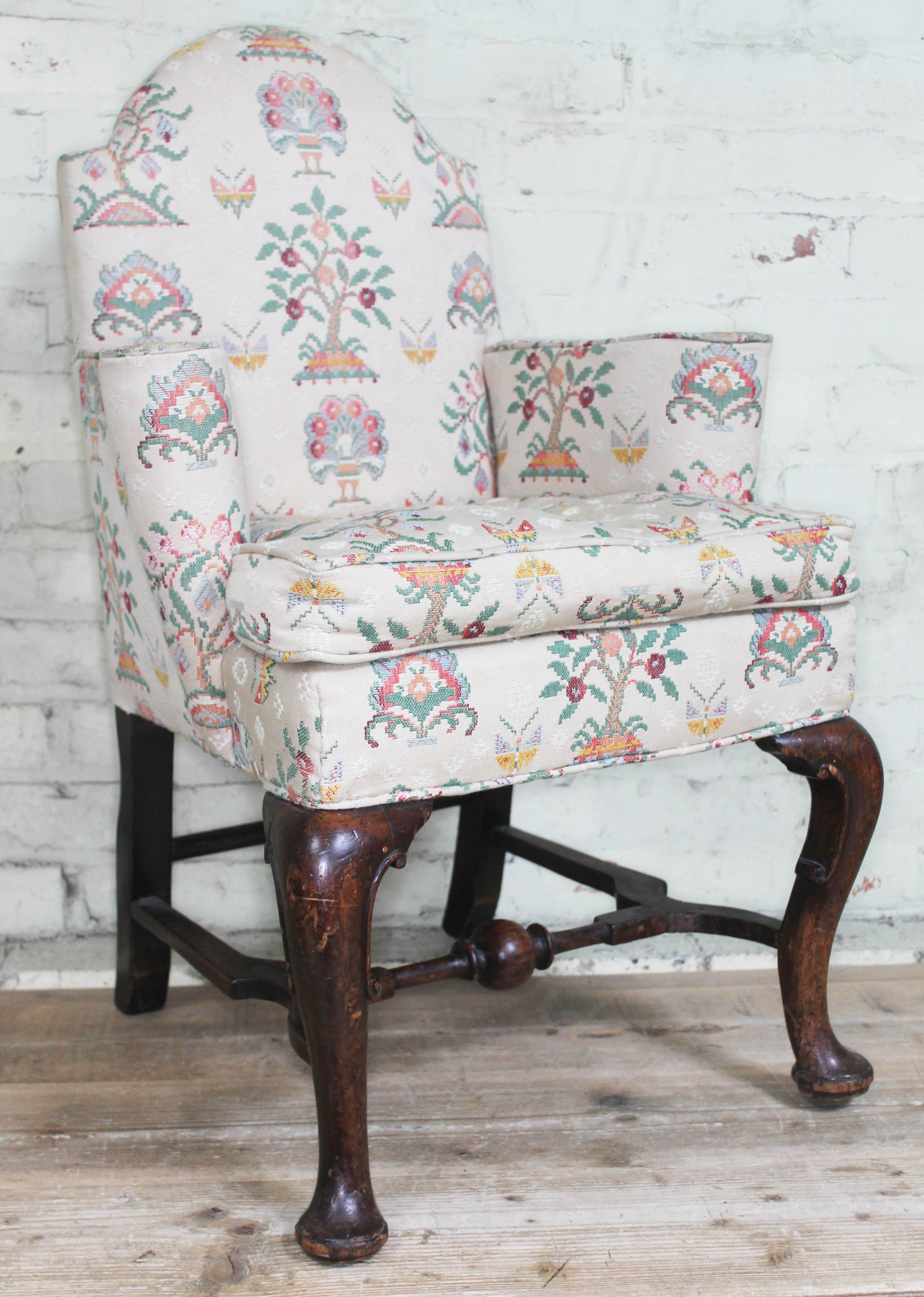 An 18th century and later oak armchair of small proportions with domed back, scroll arms and