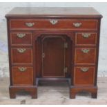 A George III mahogany knee hole desk, cross-banded top with moulded edge above one long and six