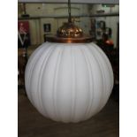 An early 20th century milk glass light fitting of spherical globe form with gilt brass fitting,