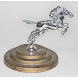 A Desmo chrome car mascot formed as a jockey and race horse, mounted on round three step base,