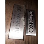 Two wristwatch shop display plaques: Seiko & Longines Official Agent.