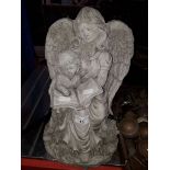 A concrete garden ornament modelled as an angel and child.