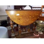 A small oak drop leaf table with turned legs.