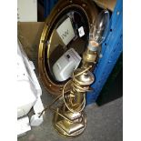 A reproduction Regency style convex mirror and a brass table lamp.