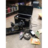 A cased Singer featherweight portable electric sewing machine No 221K, with power lead, foot pedal
