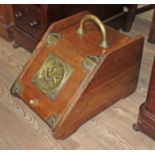 A Victorian oak coal scuttle with Aesthetic panel and brass mounts and handle.