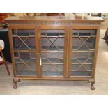 An early 20th century mahogany bookcase cabinet with fretwork frieze above three astragal glazed