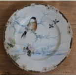 A Japanese porcelain plate decorated with a winter scene having a bird on a branch, eight