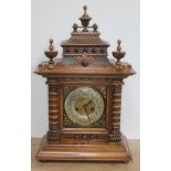 A German late 19th century walnut mantle clock of architectural form with pagoda top, finials,