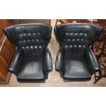 A pair of G-Plan 'Blofeld' black rexene retro swivel armchairs with arched buttoned wing back