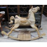 A carved pine rocking horse, height 109cm, length 147cm, width 54cm.