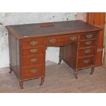 A late Victorian oak pedestal desk with tooled brown leather writing surface over frieze drawers