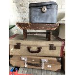 Two vintage suitases, a vanity case, and an old stool