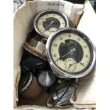 A box containing vintage car speedometers and other dials