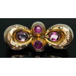 A Victorian brooch of bow form and set with four purple garnets, unmarked, length 42mm, gross wt.
