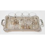 An Edwardian liqueur set comprising a twin handle tray with gradrooned border and six silver mounted