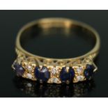 An early 20th century diamond and sapphire ring, the stones within scroll setting, hallmarked 18ct