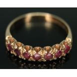 A hallmarked 9ct gold seven stone ruby ring, gross wt. 2.30g, size N. Condition - line to back of