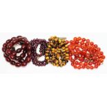 A group of four beaded necklaces comprising cherry bakelite length 42cm, purple garnet length