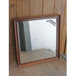 A rectangular oak framed bevelled mirror 85cm x 89cm.