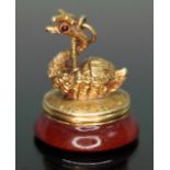 A yellow metal seal fob modelled as a swan set with red stones for eyes and sat above a carnelian