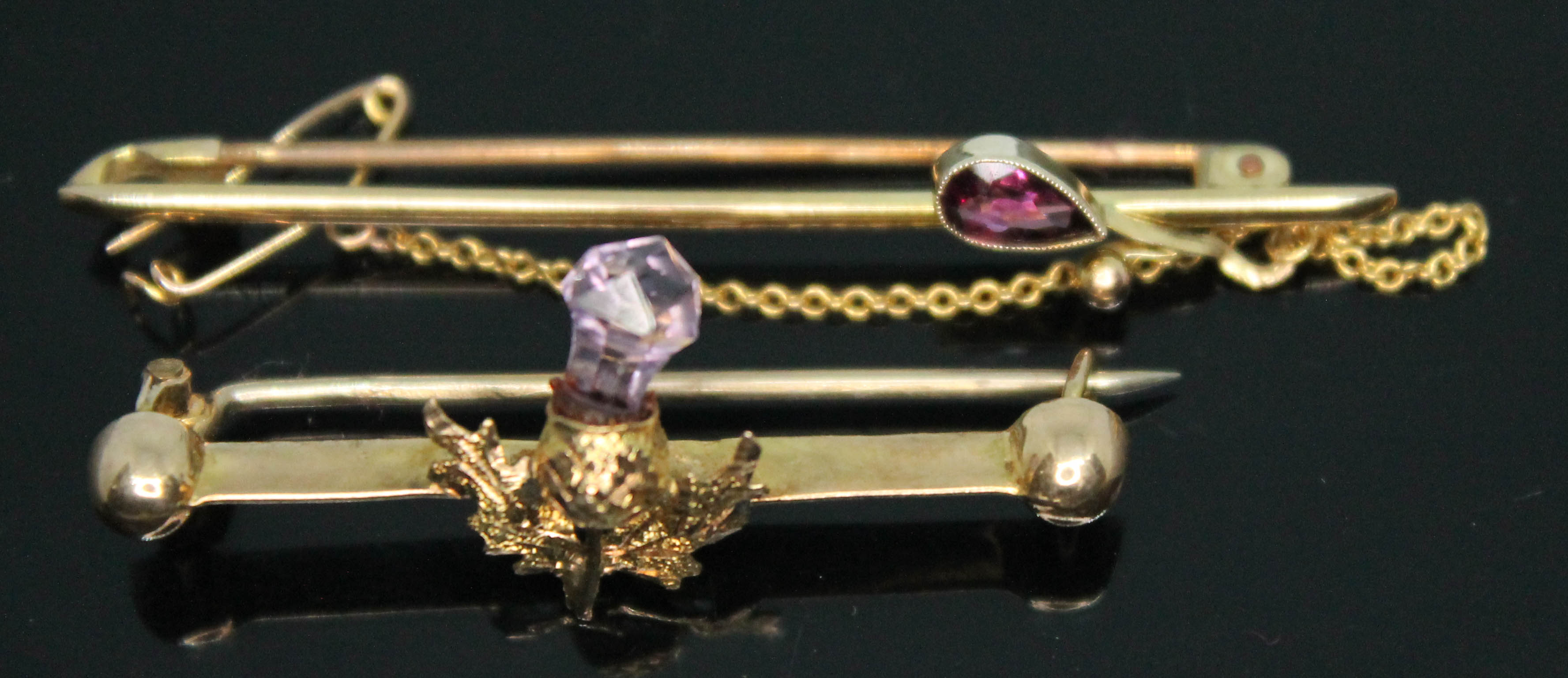 Two bar brooches set with amethyst, one formed as a thistle, both marked '9ct, gross wt. 3.38g,