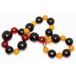 A single strand of vintage cherry and orange bakelite beads, ranging in diameter from 10mm to