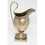 An Edwardian hallmarked silver pedestal cream jug, height 14cm, weight 4oz. Condition - general,