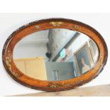 A 1920s oval oak mirror with chinoiserie decoration 82cm x 54cm.