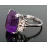 An Art Deco period diamond and amethyst ring, the emerald cut purple amethyst weighing approx. 9.