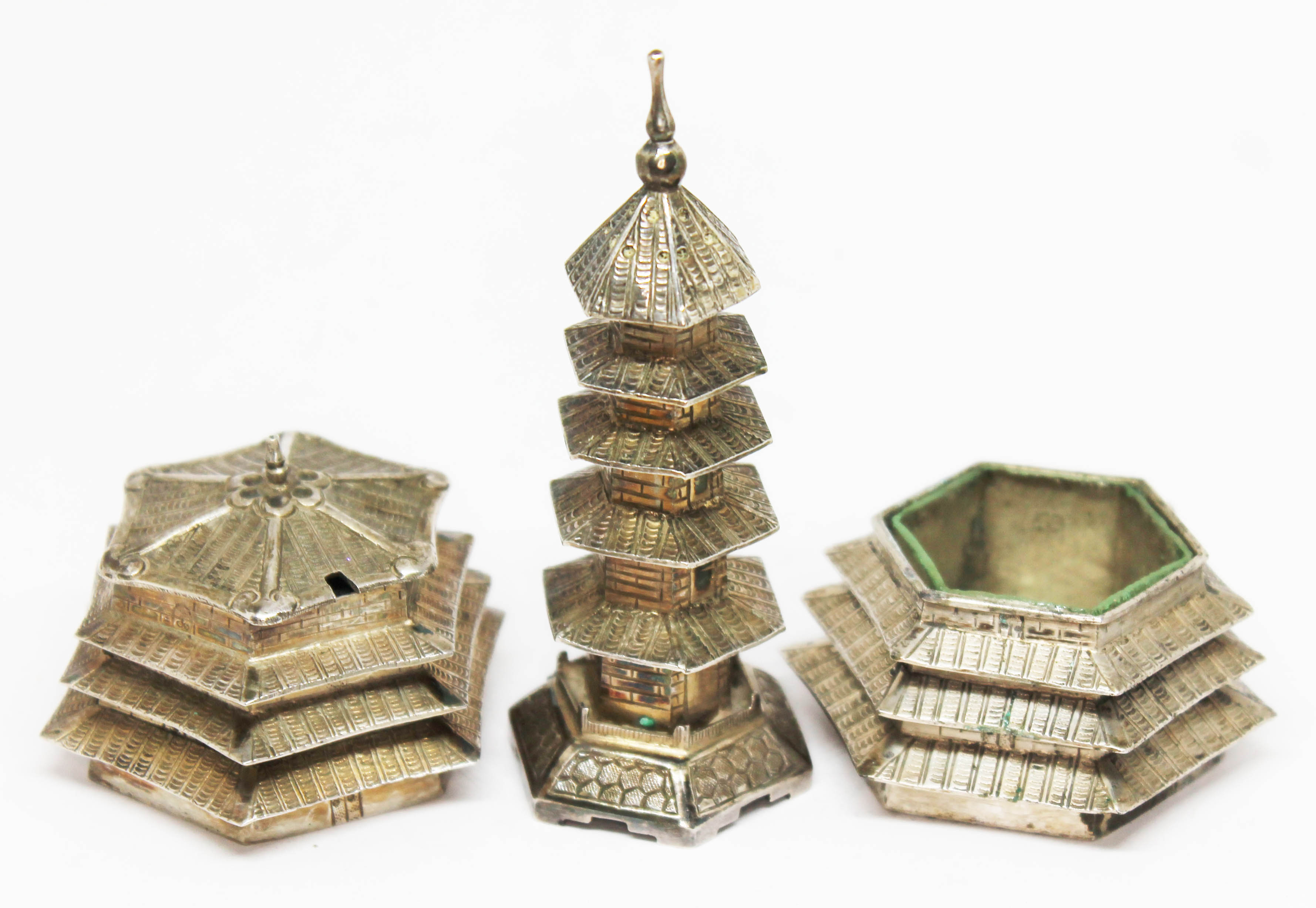 A Chinese three piece cruet, each piece modelled as a pagoda, marked 'Silver' with Chinese