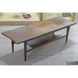 A teak surfboard coffee table, length 121cm. Condition - top marked and faded, a little play in